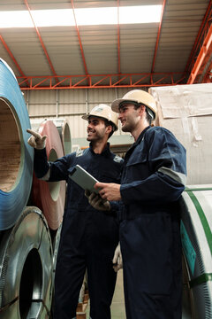 Engineers and staff are inspecting the assembly line system in a metal sheet and metal roofing manufacturing plant.