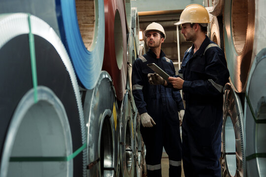 Engineers and staff are inspecting the assembly line system in a metal sheet and metal roofing manufacturing plant.