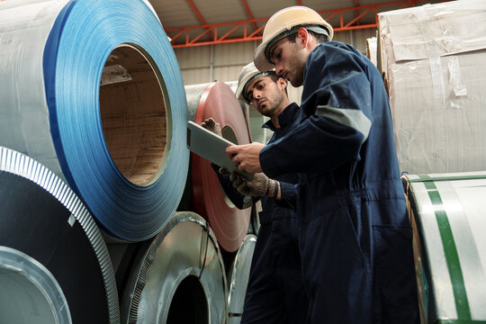 Engineers and staff are inspecting the assembly line system in a metal sheet and metal roofing manufacturing plant.