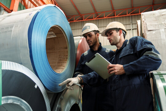Engineers and staff are inspecting the assembly line system in a metal sheet and metal roofing manufacturing plant.