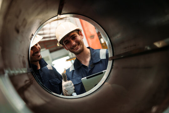 Engineers and staff are inspecting the assembly line system in a metal sheet and metal roofing manufacturing plant.