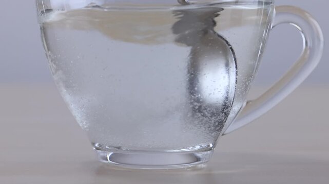 Stirring Sugar into Hot Water in a Transparent Glass Cup