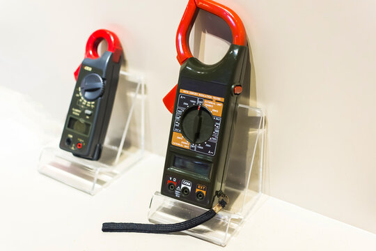 Portable clamp voltmeters on display stands for electrical testing