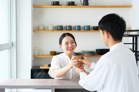 Young Japanese Woman Laughing and Talking with Cafe Staff at Counter