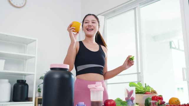 Fit Asian woman presenting organic food recipes for fitness goals on vlog channel. Sporty female content creator recording health and wellness tips with mobile phone camera.