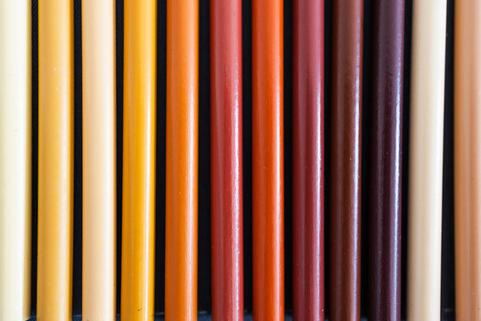 close-up of ochre brown and skin tones pencils neatly lined up in pencil case, concept of creativity, drawing, education and art supplies