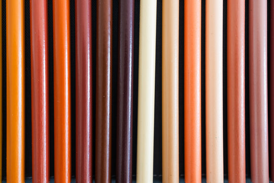 close-up of ochre brown and skin tones pencils neatly lined up in pencil case, concept of creativity, drawing, education and art supplies