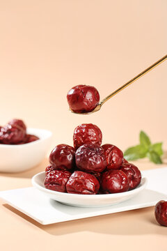 Red Dried Jujube Dates from Hetian Xinjiang on White Plate with Golden Spoon - Traditional Chinese Superfood