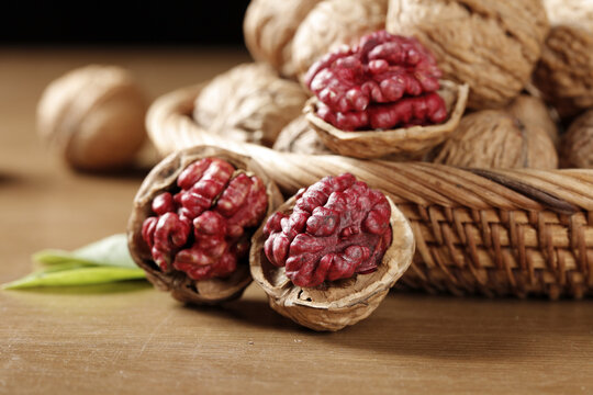 Red Paper Skin Xinjiang Walnuts Cracked Open Showing Fresh Walnut Kernels on Wood Surface