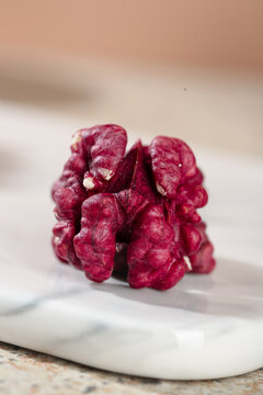 Red Walnut Kernel with Natural Crimson Skin on White Paper Background