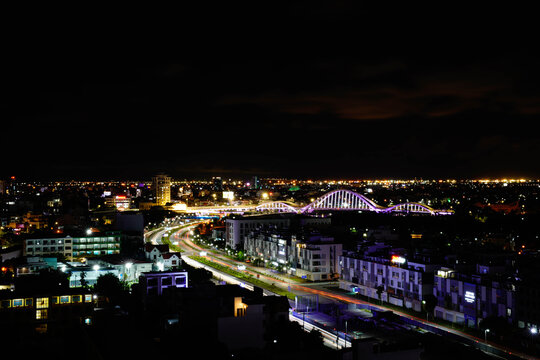 A stunning aerial night view of a vibrant cityscape, showcasing illuminated buildings.