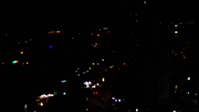 Abstract city lights at night, featuring blurred urban vibrancy.