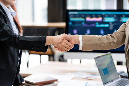 Business People Handshake Deal with Financial Data Dashboard Background in Office
