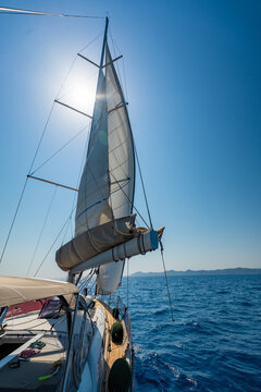 Mainsail on a sailing yacht while cruising across the sea under a clear blue sky. Concept of wind power, sailing, navigation, freedom and life aboard.