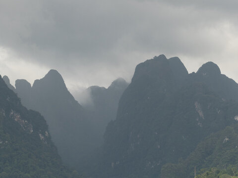 Ratchaprapha Dam on a rainy day at khao sok national park, surat thani province thailand featuring spectacular limestone mountains shrouded in mist.