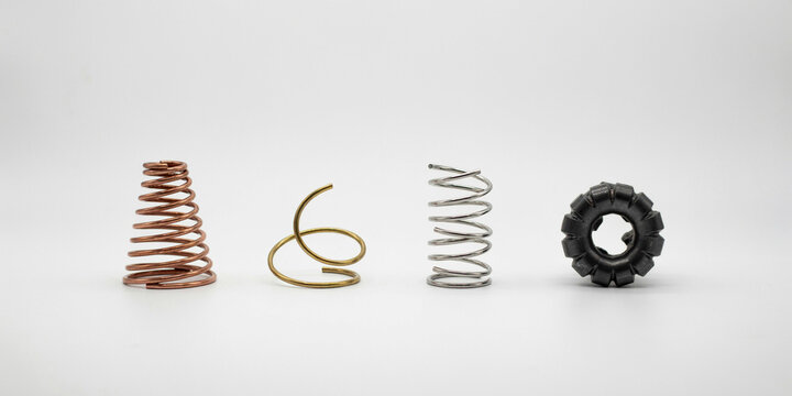 Four industrial metal springs and a gear component on white background