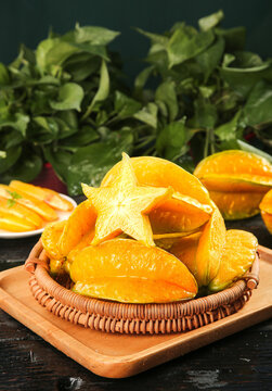 Fresh Star Fruit Slices in Wicker Basket with Five-Pointed Stars Shape on Dark Background