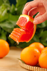 Fresh Blood Orange Slice in Hand Showing Red Flesh and Juice Dripping © TranThi