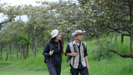 Fototapeta premium Young Couple Hiking Through Green Forest During Nature Travel Adventure