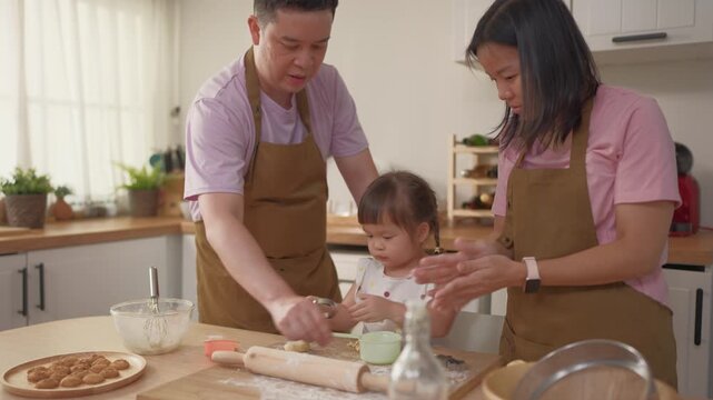 Asian mature parents lovingly care for and raises baby girl at home.