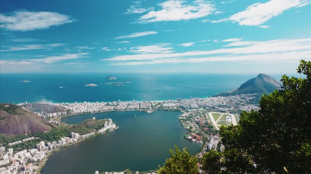 Panoramic view across Rio skyline, smoke rising from a favella, lagoon and Atlantic coastline from Corcovado.