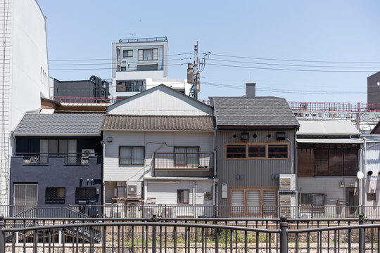 Row of traditional and modern Japanese residential buildings with power lines and copy space in Fukuoka, Japan