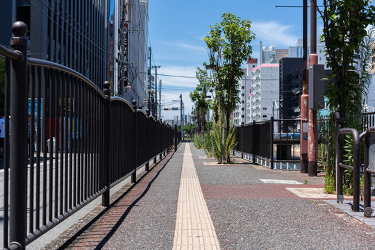 Pedestrian walkway with metal railing along riverside in Fukuoka, Japan with copy space