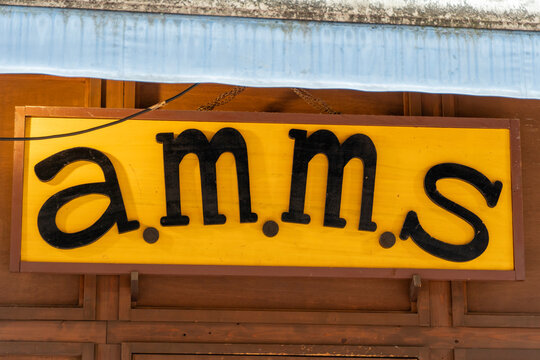 SUGINAMI-KU, TOKYO, JAPAN - AUGUST 15, 2026: Yellow brand logo signboard of a.m.m.s apparel shop in Suginami-ku, Tokyo.