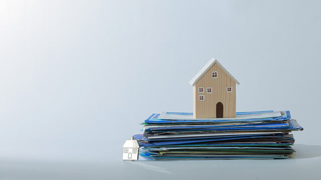 Real estate dispute mini house model stack document paper serious legal concept financial property debt problem tension insurance plan