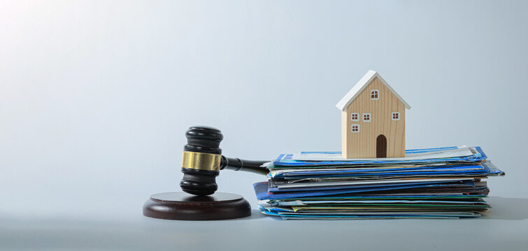 Wooden house model legal gavel stack paper document represent tense real estate dispute conflict legal action property court case concept
