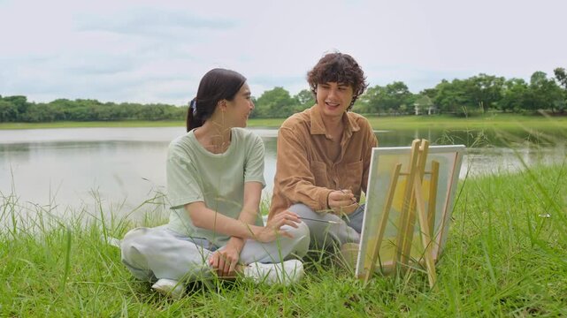 Asian young couple enjoying leisure time together outdoors in the park. 
