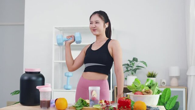 Healthy eating expert recording mobile video about fresh fruits and green veggies. Modern Asian woman in sportswear sharing wellness motivation and daily diet preparation.