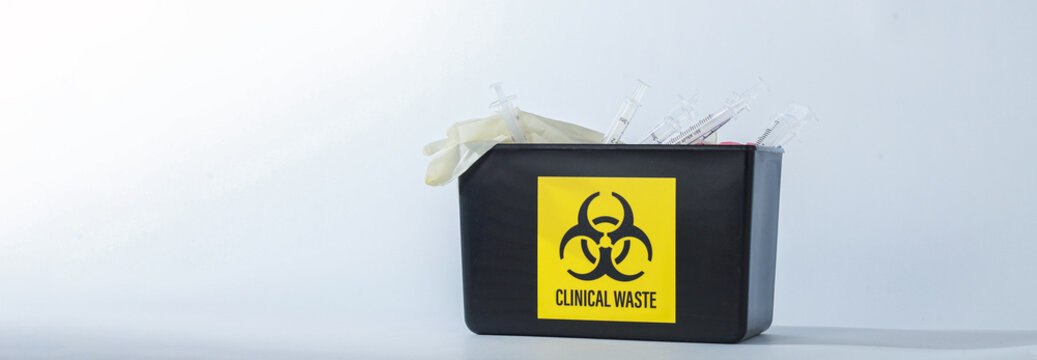 Biohazard container with yellow warning sign holds clinical waste, reflecting serious medical safety precautions clearly bright white studio