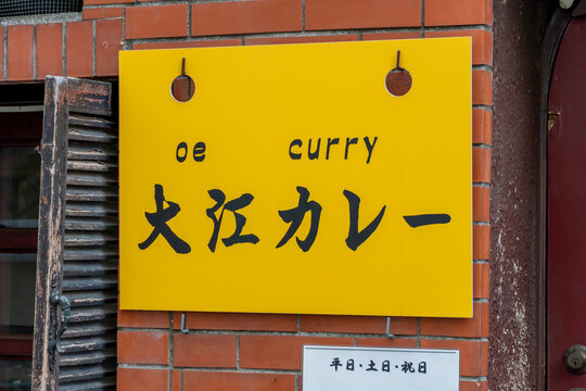 SUGINAMI-KU, TOKYO, JAPAN - AUGUST 15, 2026: Bright yellow corporate logo signboard of Ooe Curry restaurant in Suginami-ku, Tokyo.