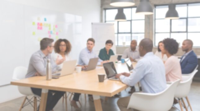 Blurred professional business team in office conference room sitting at wooden table with laptops for collaborative corporate project meeting and strategic planning in modern workspace setting
