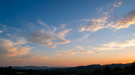 Obraz premium Vast sky painted with sunset hues over rolling hills.