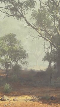 A tranquil morning scene unfolds with soft mist enveloping tall trees and shrubs. Gentle light filters through, creating a peaceful atmosphere in an untouched landscape.