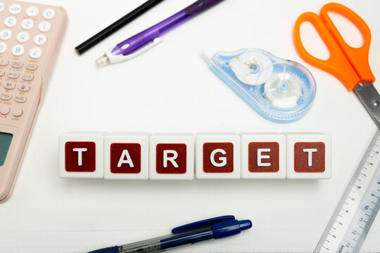 Business organization and administration concept featuring letter blocks spelling &ldquo;TARGET&rdquo; on a clean office desk, surrounded by office stationaries.
