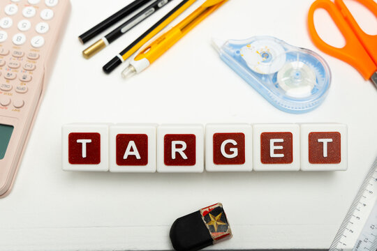 Business organization and administration concept featuring letter blocks spelling &ldquo;TARGET&rdquo; on a clean office desk, surrounded by office stationaries.
