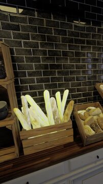 A cozy bakery features wooden crates filled with an assortment of fresh breads and rolls. The warm glow highlights the crusty loaves, inviting customers to indulge in delightful treats.