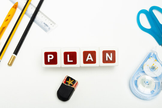Business organization and administration concept featuring letter blocks spelling &ldquo;PLAN&rdquo; on a clean office desk, surrounded by office stationaries. Symbolizing corporate mission, strategic planning, b