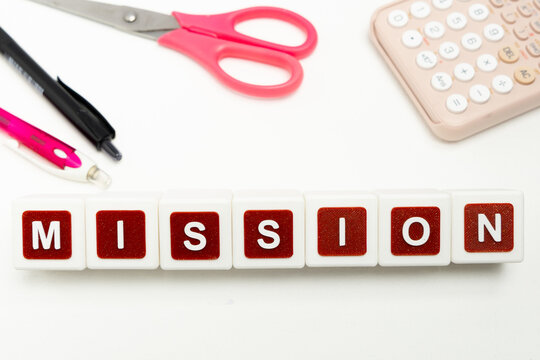 Business organization and administration concept featuring letter blocks spelling &ldquo;MISSION&rdquo; on a clean office desk, surrounded by office stationaries.