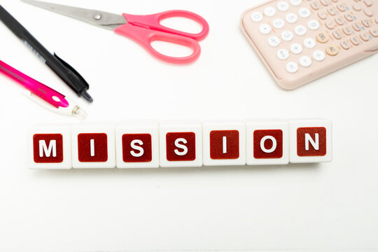 Business organization and administration concept featuring letter blocks spelling &ldquo;MISSION&rdquo; on a clean office desk, surrounded by office stationaries.