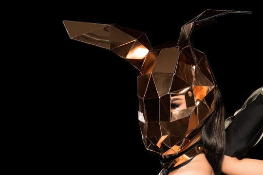 Woman wearing reflective golden rabbit mask at night
