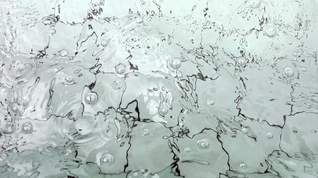 Clear fountain water creates delicate ripples above pale tiled pool floor