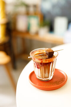 Glass of layered milk latte by the window.