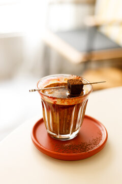 Glass of layered milk latte by the window.