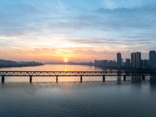 Fototapeta premium sunset view of a large bridge spanning the river with city skyline