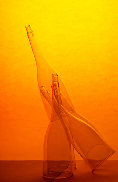 Still life with transparent empty glasses on a yellow-orange background