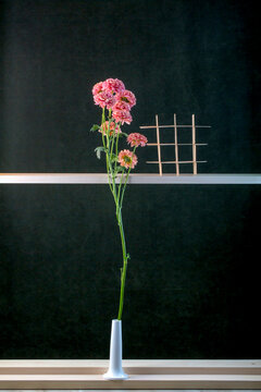 Still life with a bouquet of flowers and a wooden board on a green background